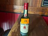 une bouteille de Jameson posée sur une table en bois dans un bar