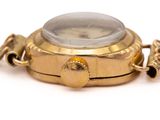 a gold watch with a chain around it on a white surface