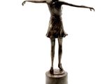 bronze statue of a woman with arms outstretched on a pedestal