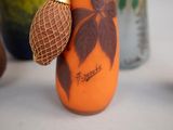 an orange vase with a brown flower on it