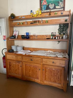 une armoire en bois surmontée d'une étagère, dans une cuisine