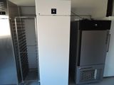 two refrigerators that are next to each other in a room