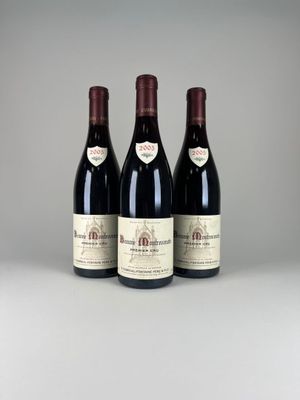 trois bouteilles de vin rouge posées sur une table