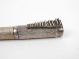 a silver pen with a wooden handle on a white surface
