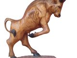 statue of a bull on a wooden base on a white background