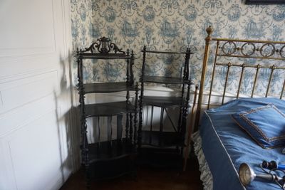 un lit et une chaise dans une pièce dont l'un des murs est tapissé