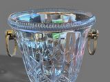 a glass vase with a gold handle on a gray surface