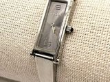 une montre-bracelet posée sur une serviette de table, elle-même posée sur une nappe blanche