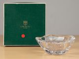 an image of a glass bowl sitting on a table next to a green box