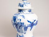 un vase bleu et blanc avec un couvercle posé sur une table