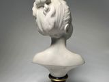 a white busturine of a woman with a bun on her head