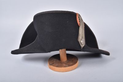 hat on a wooden stand on a white surface with a white background
