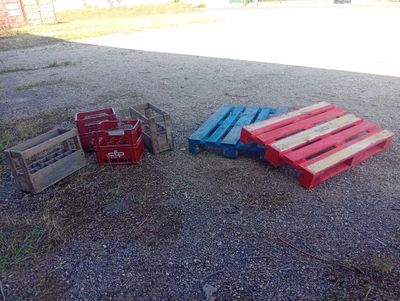 several pallets of different colors sit on the ground next to each other