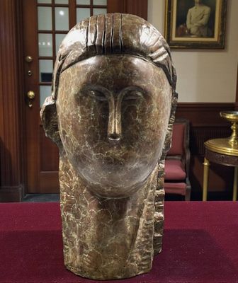 sculpture of a woman ' s head on a table in a room