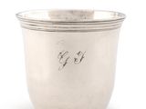 an antique silver cup with a writing on the side