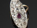 une photo d'une bague sertie d'un diamant et d'un rubis sur un fond noir
