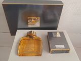a bottle of perfume sitting on a table next to a box