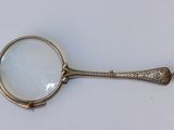une loupe munie d'un manche, posée sur une table
