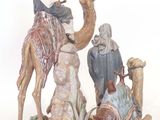 figurine of a man on a camel with three men and a dog