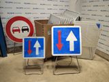 two signs that are on a stand in front of a wall