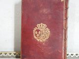 a red book with a crown on it sitting on a table