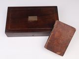 an old wooden box sitting on top of a table next to a book