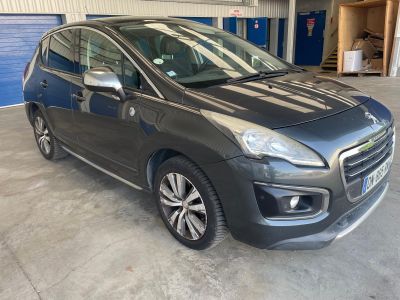 une voiture grise garée dans un garage, à côté d'une porte de garage bleue