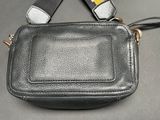 a small black purse with a yellow and white tag on it