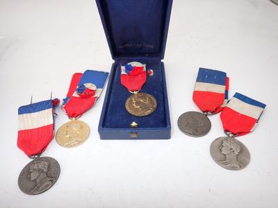 three medals and a medal in a blue case on a table