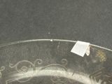 a close up of a silver plate with a sticker on it
