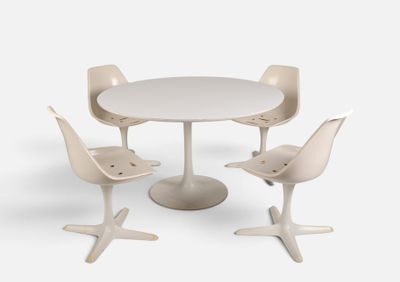 quatre chaises disposées autour d'une table au plateau blanc
