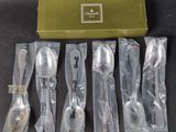 cinq cuillères en argent et deux cuillères en argent dans des sachets en plastique