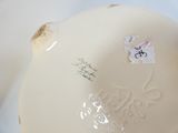 a close up of a white vase with a sticker on it