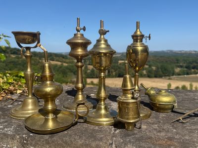 cinq types différents de bougies en laiton posées sur une table