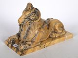 statue d'un lion posée sur un socle en pierre, sur fond blanc