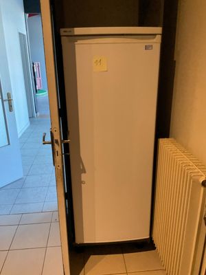 un réfrigérateur blanc posé dans le coin d'une pièce