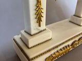 a white and gold clock sitting on top of a table