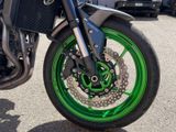 a motorcycle parked in a parking lot with green rims