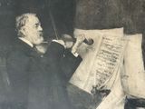 painting of a man sitting in a chair holding a violin and looking at a sheet of music