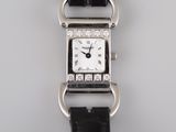 a close up of a watch on a black strap on a white surface