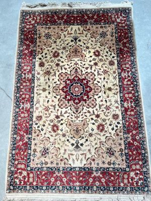an oriental rug with a red border and floral design