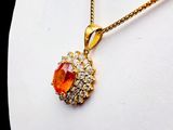 gold plated necklace with orange and white stones on a mannequin torso