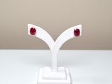 pair of red stone earrings on white stand on white surface
