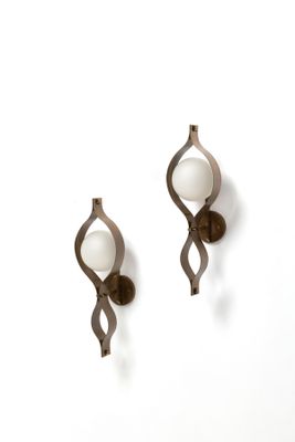 une paire d'appliques murales ornées chacune d'une boule en verre blanc