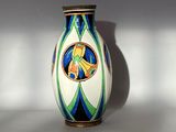 un vase blanc orné d'un motif bleu et vert