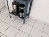 a microwave sitting on a small table in the kitchen