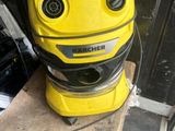 un aspirateur jaune et noir posé sur un parquet