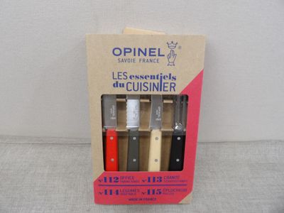 quatre couteaux dans une boîte posée sur une table