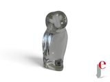 a glass owl figurine sitting on a white surface
