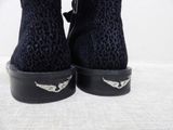 someone is wearing a pair of black boots with silver wings on them